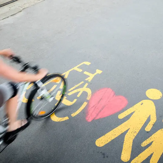 Velofahrerin fährt über Piktogramme auf der Strasse