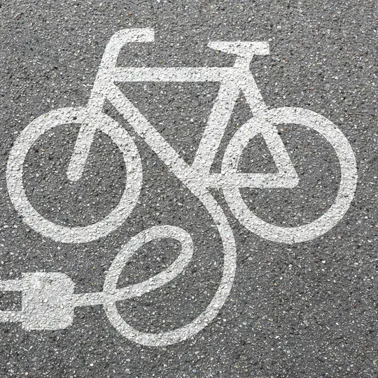 Elektro-Velo mit Ladekabel auf Strasse gemalt