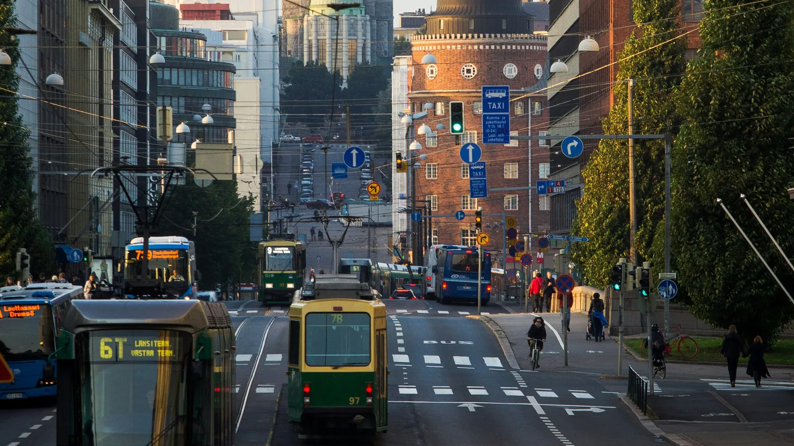 Blick entlang einer Strasse in Helsinki, zu sehen sind Trams, eine leere Autospur und ein breiter Veloweg