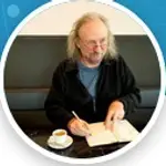 Mann beim Kaffee schreibt in ein Buch