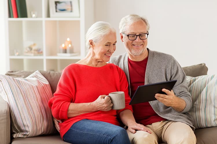Älteres Paar am Tablet Spenden